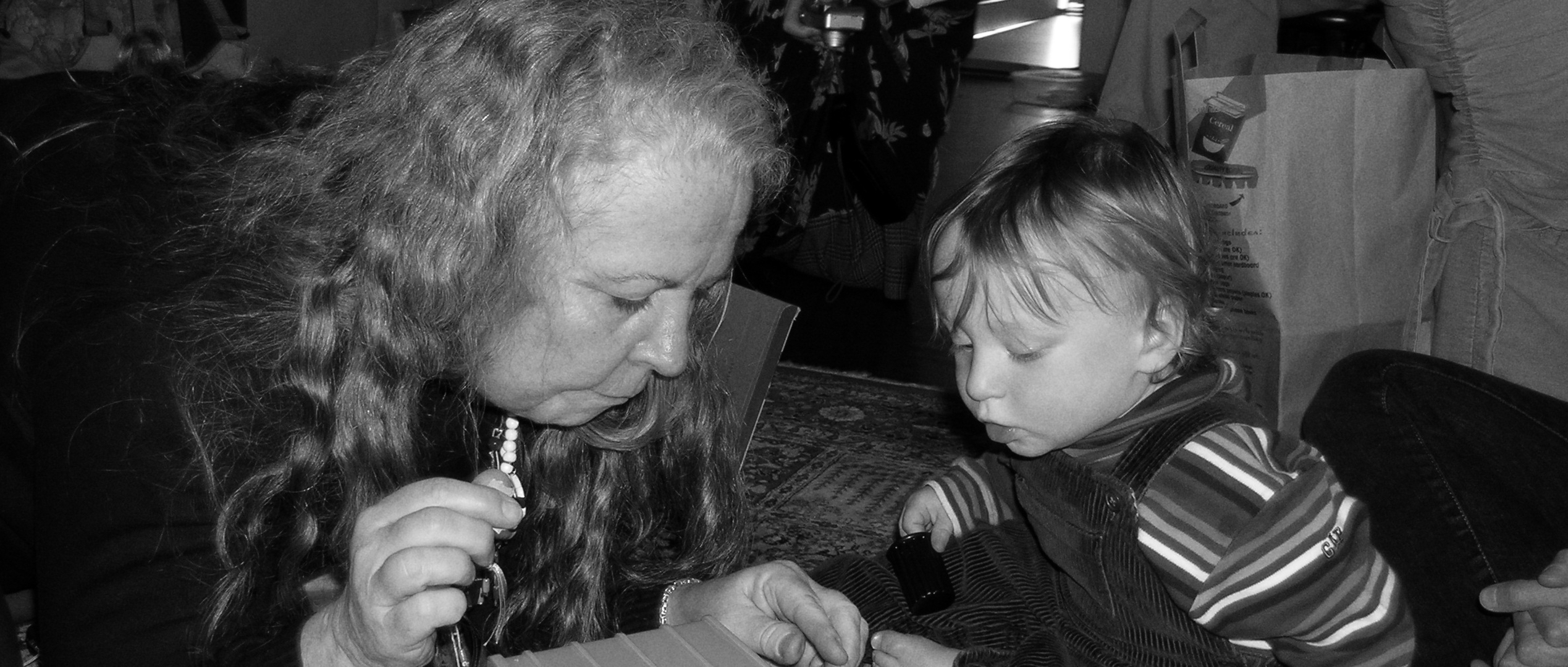 An older woman with long hair and a young boy in a black and white photo.